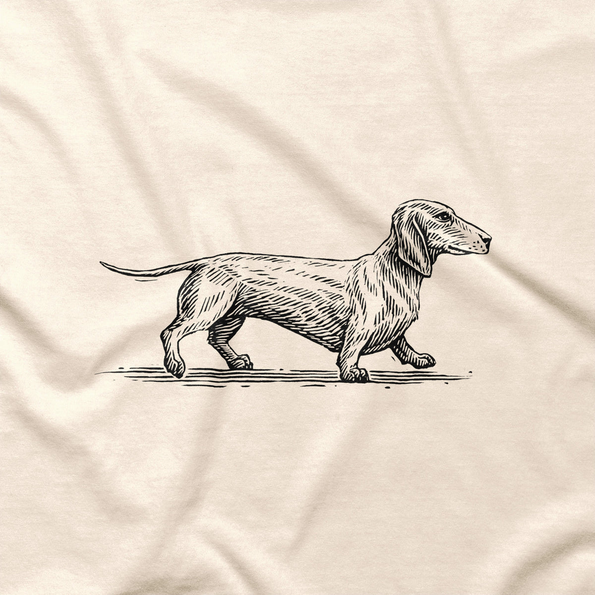Close-up of the black Dachshund illustration printed on a natural-colored T-shirt